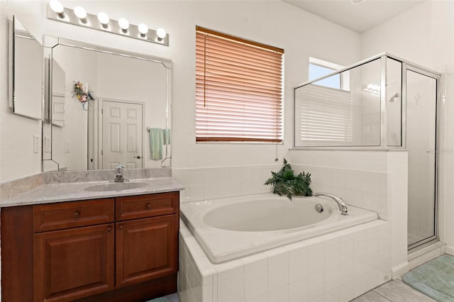 bathroom with shower with separate bathtub, vanity, and tile patterned flooring