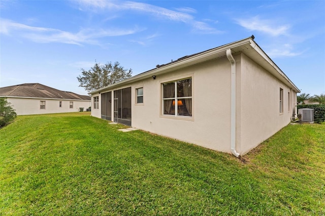 rear view of property featuring central air condition unit and a yard