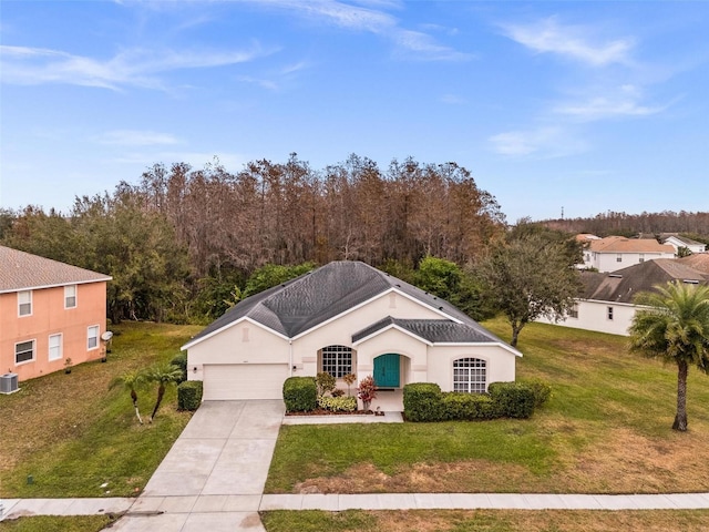 view of front facade featuring a front yard, central AC, and a garage