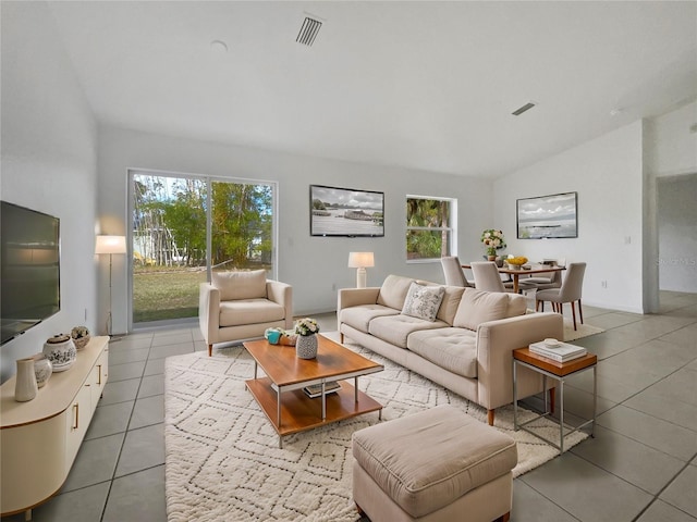 living room with lofted ceiling and light tile patterned floors