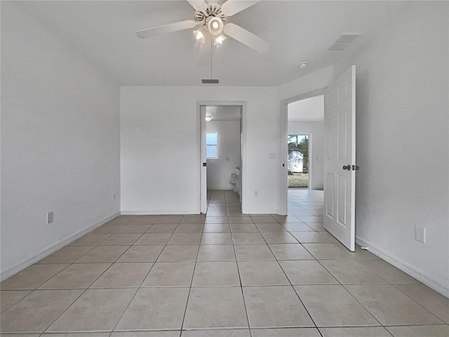 tiled spare room featuring ceiling fan