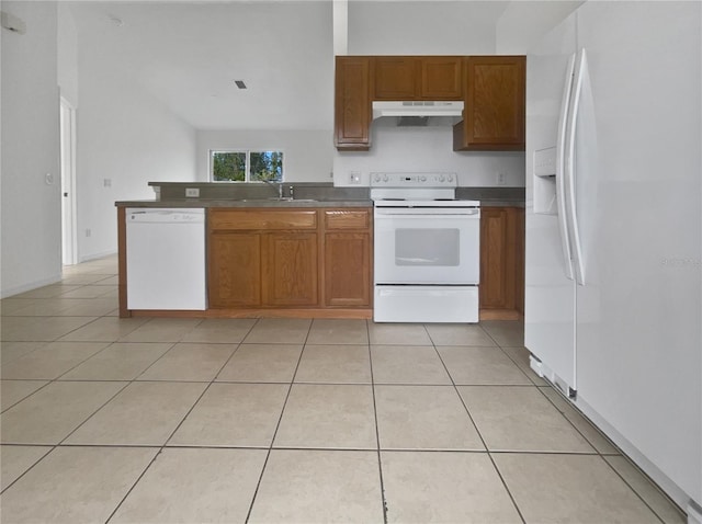 kitchen with white appliances, kitchen peninsula, light tile patterned flooring, and sink