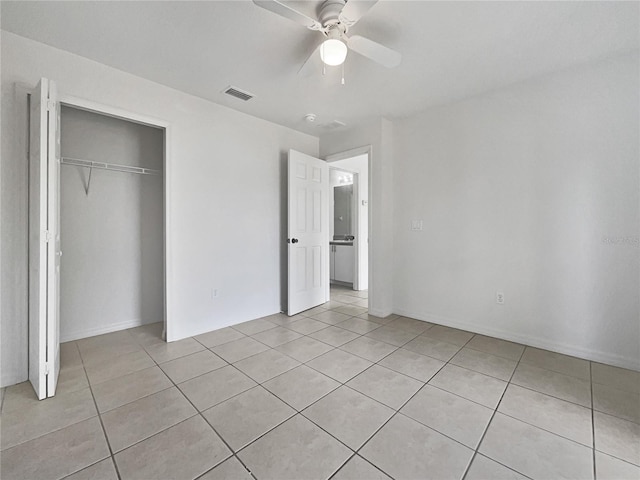 unfurnished bedroom with ceiling fan, light tile patterned floors, and a closet