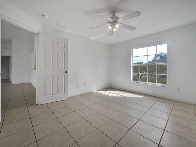 tiled spare room with ceiling fan