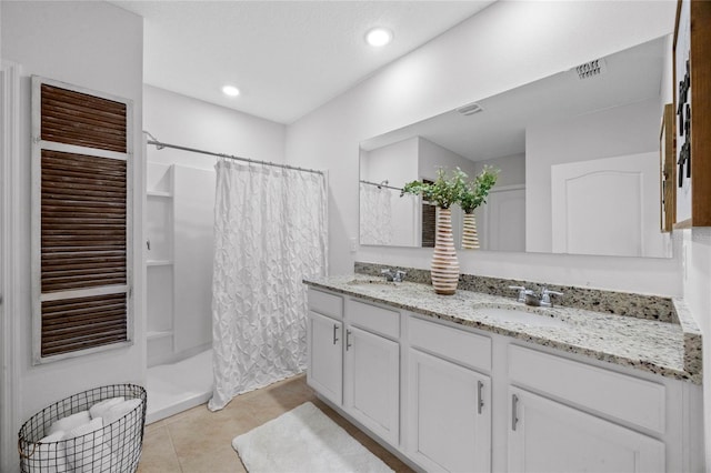 bathroom with walk in shower, tile patterned floors, and vanity