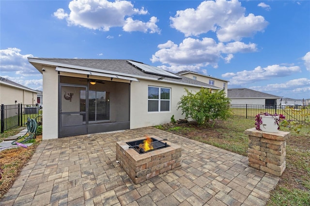 back of property with an outdoor fire pit, a patio area, and solar panels