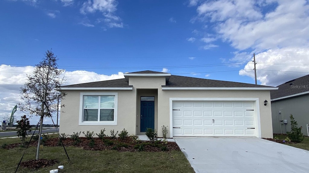 view of front facade featuring a front yard and a garage