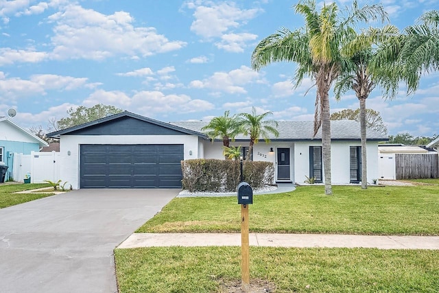 ranch-style house featuring a front lawn and a garage