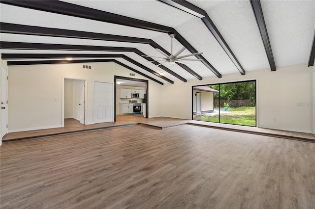 unfurnished living room featuring vaulted ceiling with beams, visible vents, ceiling fan, wood finished floors, and baseboards