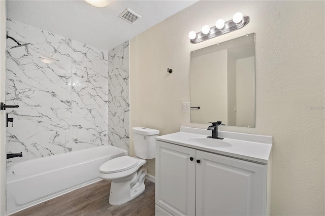 full bathroom with a textured ceiling, bathtub / shower combination, hardwood / wood-style flooring, toilet, and vanity