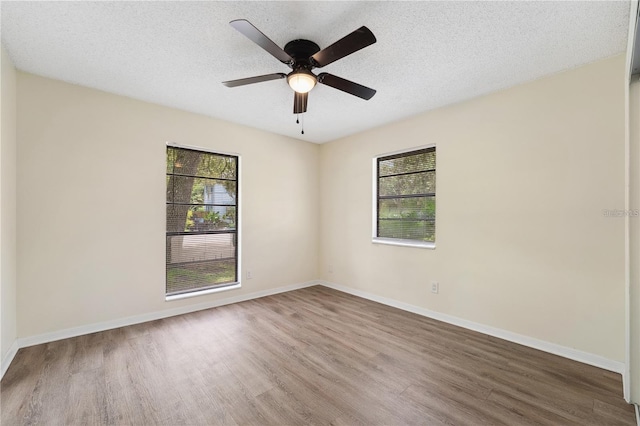 unfurnished room featuring a ceiling fan, a textured ceiling, baseboards, and wood finished floors