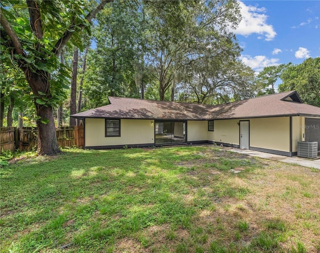 ranch-style house with fence, central AC, and a front yard