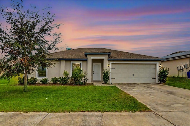 view of front of home with a garage and a yard