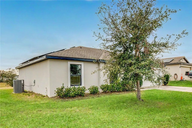 view of front facade featuring central AC unit and a front yard