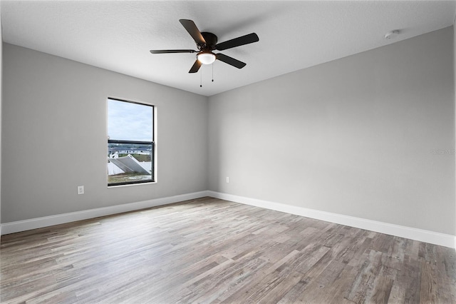 spare room featuring a textured ceiling, ceiling fan, and light wood-type flooring