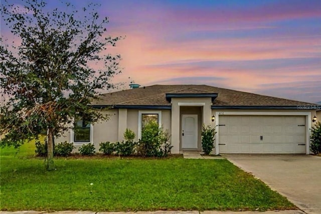 1952 Piedmont Ct, Mascotte, FL 34753 - view of front of house featuring stucco siding, a garage, driveway, a lawn, and roof with shingles
