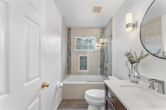 full bathroom featuring toilet, vanity, and tiled shower / bath combo