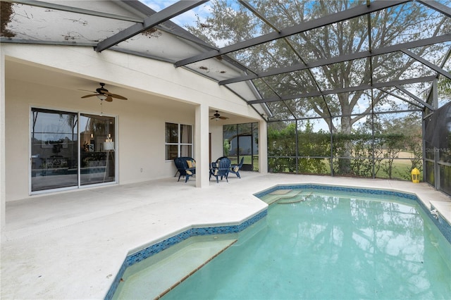 view of pool with a patio, ceiling fan, and glass enclosure