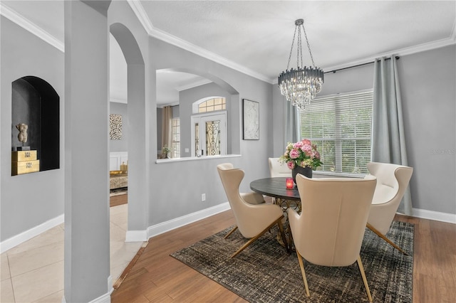 dining area featuring light hardwood / wood-style flooring, crown molding, and a chandelier