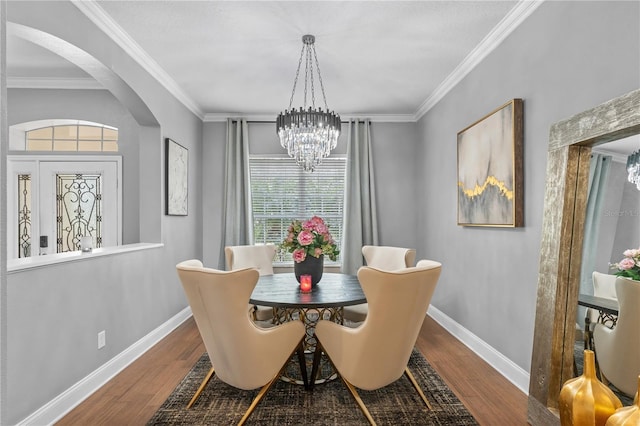 dining room featuring ornamental molding, a notable chandelier, and hardwood / wood-style flooring