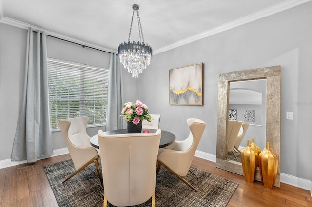 dining area featuring wood-type flooring, an inviting chandelier, and crown molding