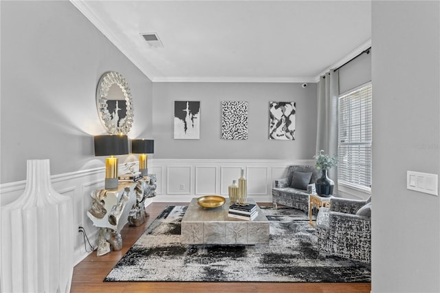 sitting room with ornamental molding and hardwood / wood-style flooring