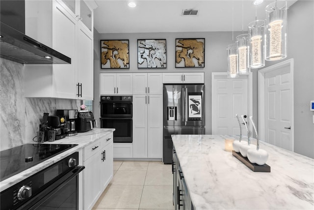 kitchen with double oven, stainless steel fridge, white cabinetry, and wall chimney range hood