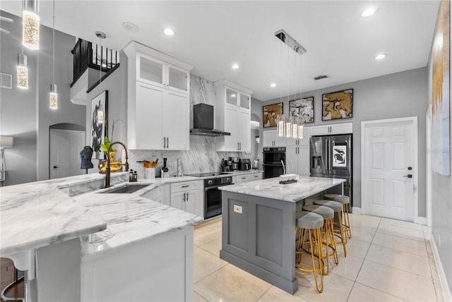 kitchen featuring stainless steel fridge with ice dispenser, a kitchen bar, white cabinets, decorative light fixtures, and sink