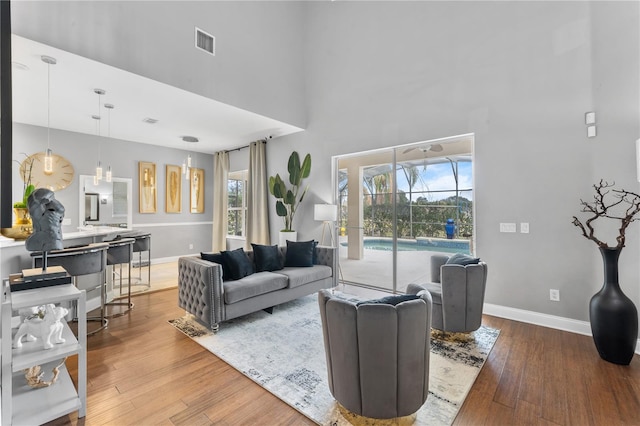 living room featuring a high ceiling and wood-type flooring