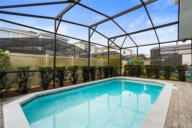 view of pool featuring glass enclosure and a patio area