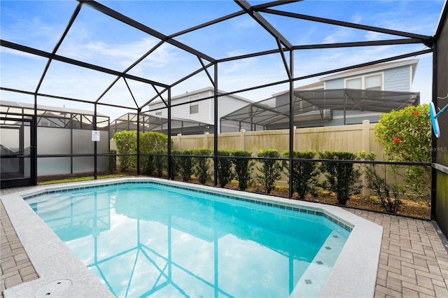 view of swimming pool featuring glass enclosure