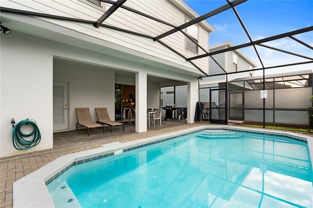 view of swimming pool with glass enclosure and a patio area