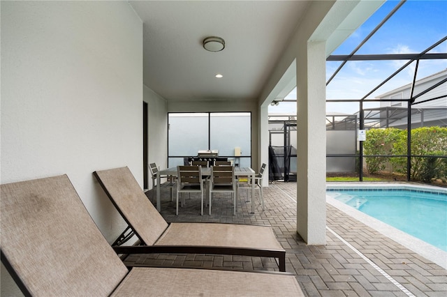 view of swimming pool with glass enclosure and a patio area