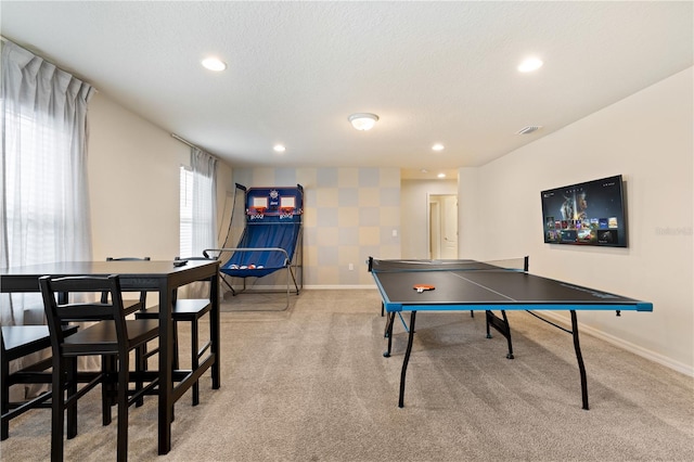 game room with a textured ceiling and light carpet