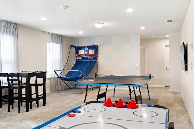 game room with light colored carpet and a textured ceiling