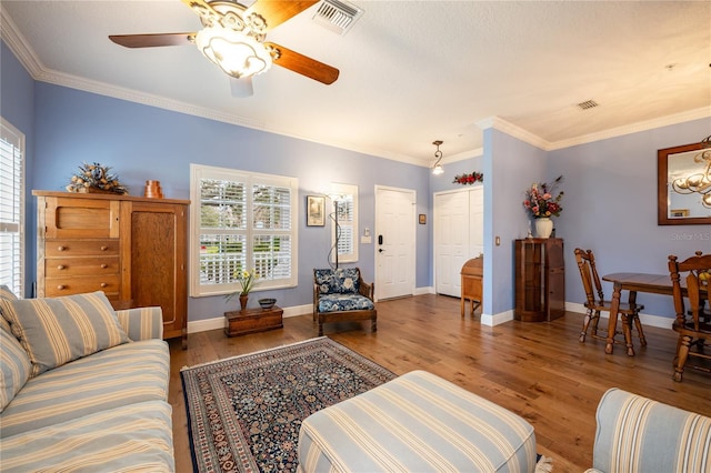 living room featuring wood-type flooring, ornamental molding, and ceiling fan