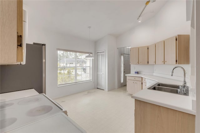 kitchen with pendant lighting, sink, stainless steel refrigerator, white range with electric cooktop, and light brown cabinets