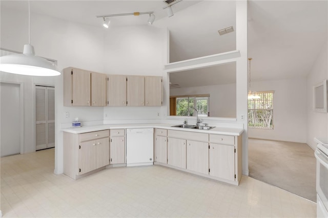 kitchen with sink, white appliances, hanging light fixtures, light carpet, and light brown cabinets