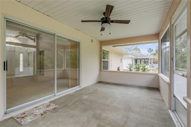 unfurnished sunroom featuring wood ceiling and ceiling fan