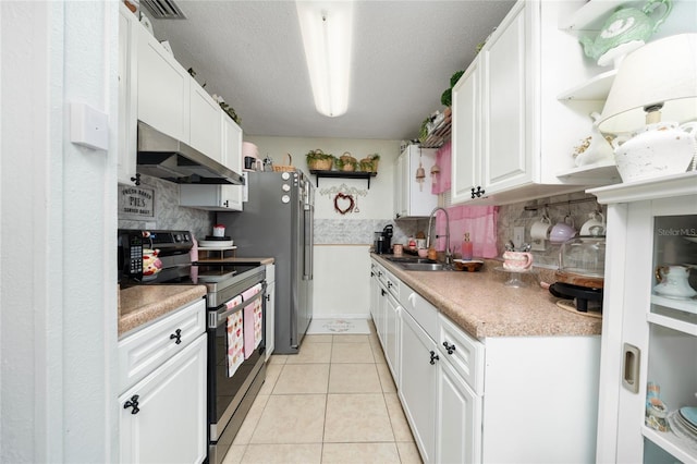 kitchen with wall chimney range hood, sink, white cabinetry, appliances with stainless steel finishes, and light tile patterned floors