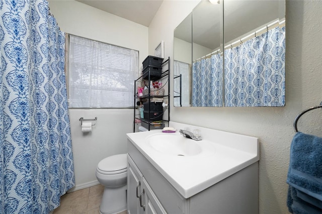 bathroom with toilet, tile patterned flooring, and vanity