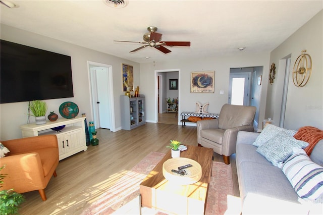 living room featuring ceiling fan and light hardwood / wood-style floors