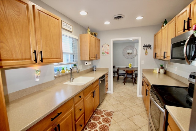 kitchen with stainless steel appliances, light tile patterned flooring, and sink