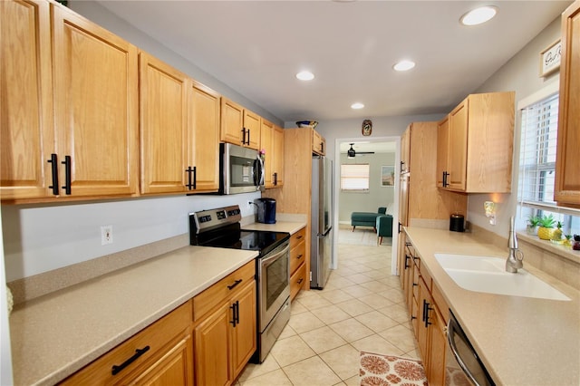 kitchen featuring stainless steel appliances, sink, light tile patterned floors, and light brown cabinets