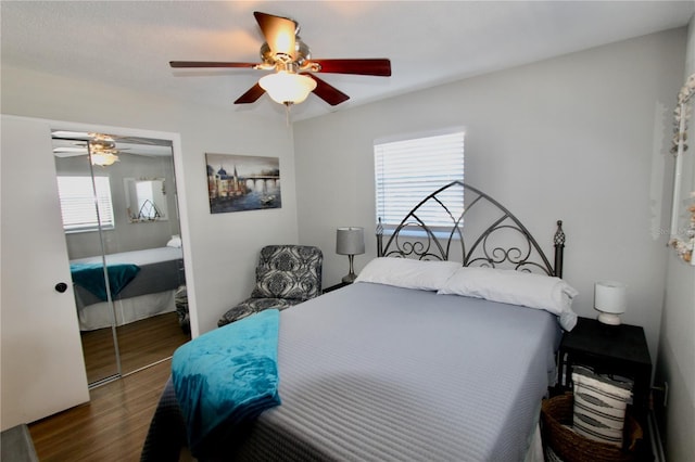 bedroom with ceiling fan, dark hardwood / wood-style floors, and a closet