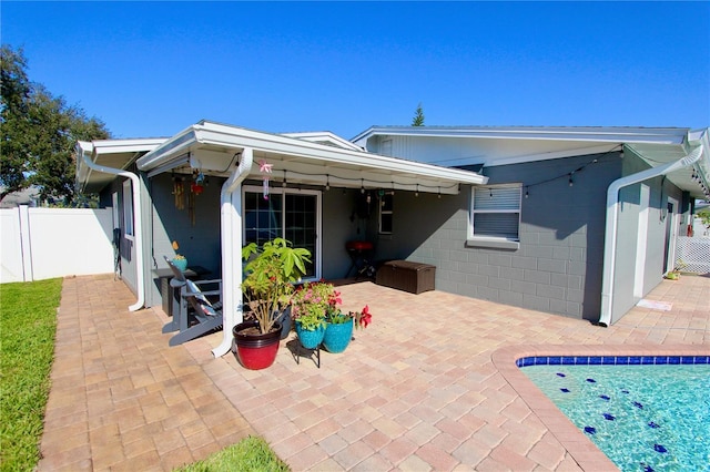 back of house with a fenced in pool and a patio