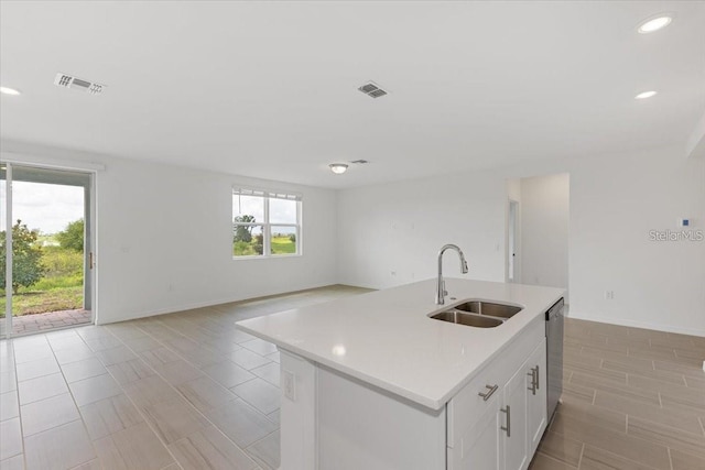 kitchen featuring sink, a center island with sink, white cabinets, and stainless steel dishwasher