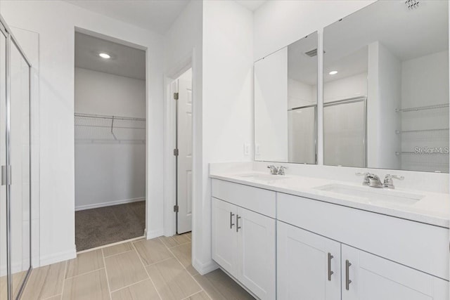 bathroom with a shower with door and vanity