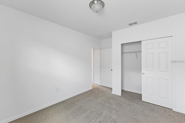 unfurnished bedroom featuring a closet and light carpet