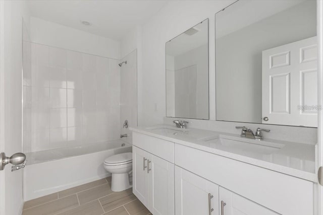 full bathroom featuring toilet, vanity, and tiled shower / bath